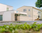 Moderne Gebäude der SRH Hochschule in einem ruhigen Umfeld, mit einer Kombination aus hellen und traditionellen Architekturelementen.