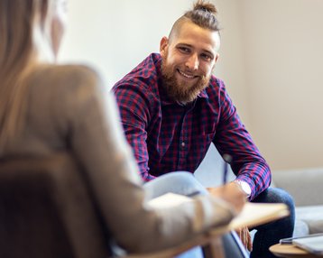 Mann spricht während der Therapiesitzung mit Therapeutin